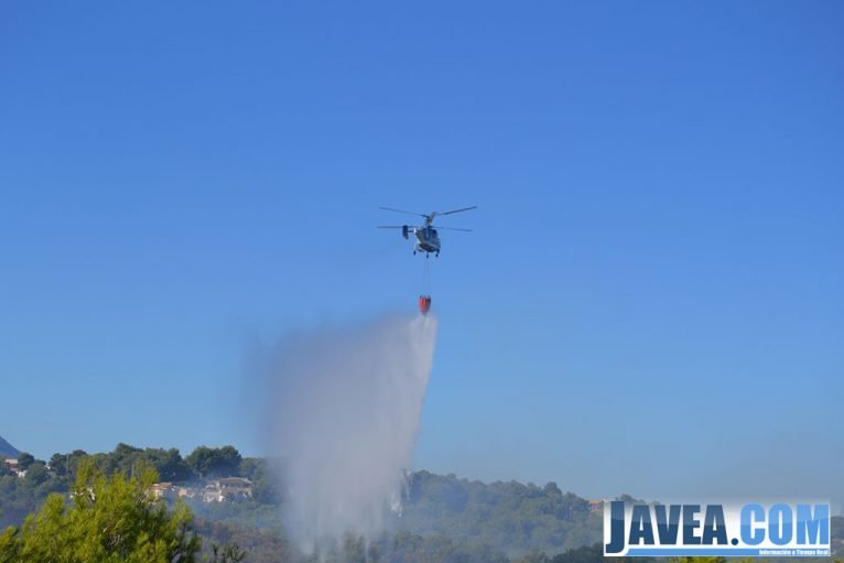 Helicóptero lanzando agua sobre la zona afectada