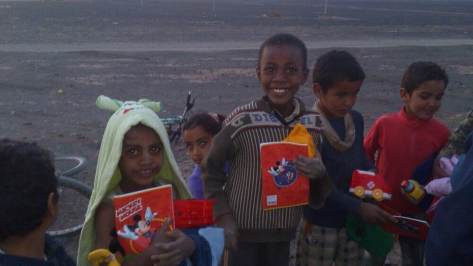 Niños y niñas de Merzouga con el material que recibieron gracias al rally solidario Maroc Challenge