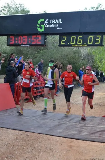 Grupo de corredores cruzando la línea de meta juntos