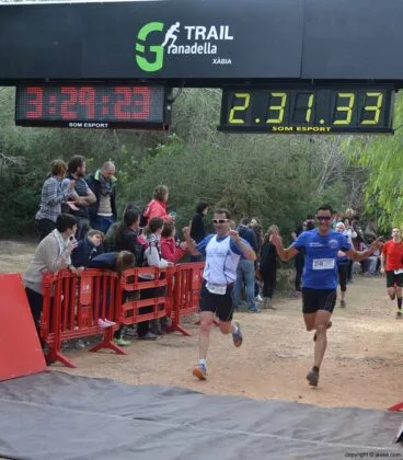 Pareja de corredores cruzando la línea de meta