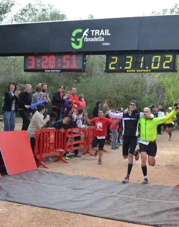 Pareja de corredores cruzando la línea de meta situada en el Parque de Pinosol de Jávea