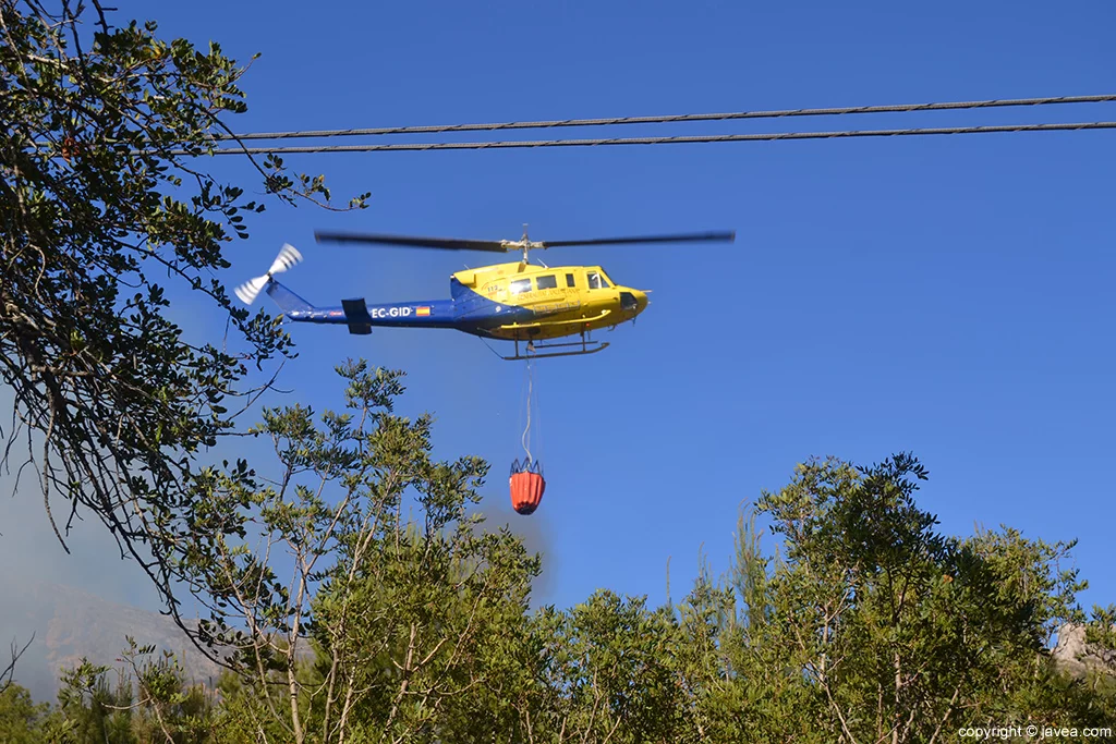 Helicóptero bajando a llenar el depósito de agua para las labores de extinción
