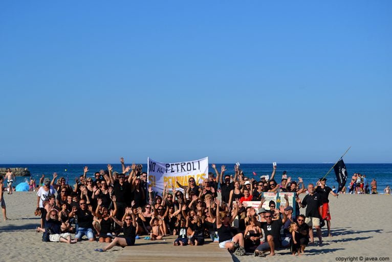 Grupo de participantes en la cadena humana en la playa del arenal
