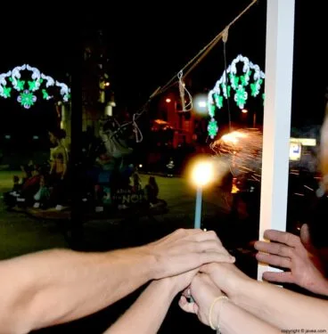 Las manos de los cargos de Fogueres 2014 encendiendo la mecha para quemar la Foguera