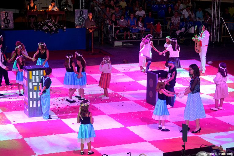 Los niños y niñas participantes bailando sobre el tablero durante la representación