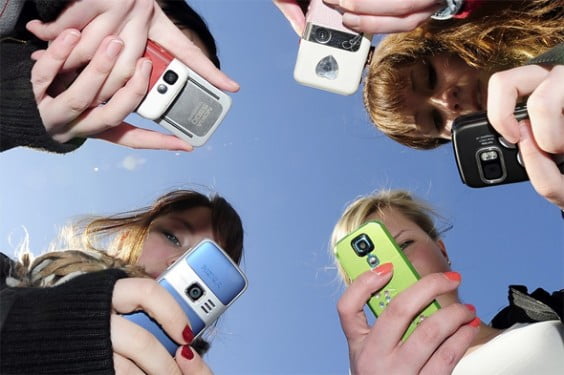 Grupo de jóvenes con sus teléfonos móviles