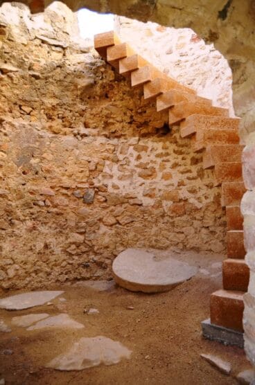 Interior del molino número 2 donde se aprecia parte de la muela y la escalinata al segundo piso