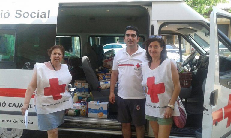Voluntarios con la ambulancia cargada de alimentos