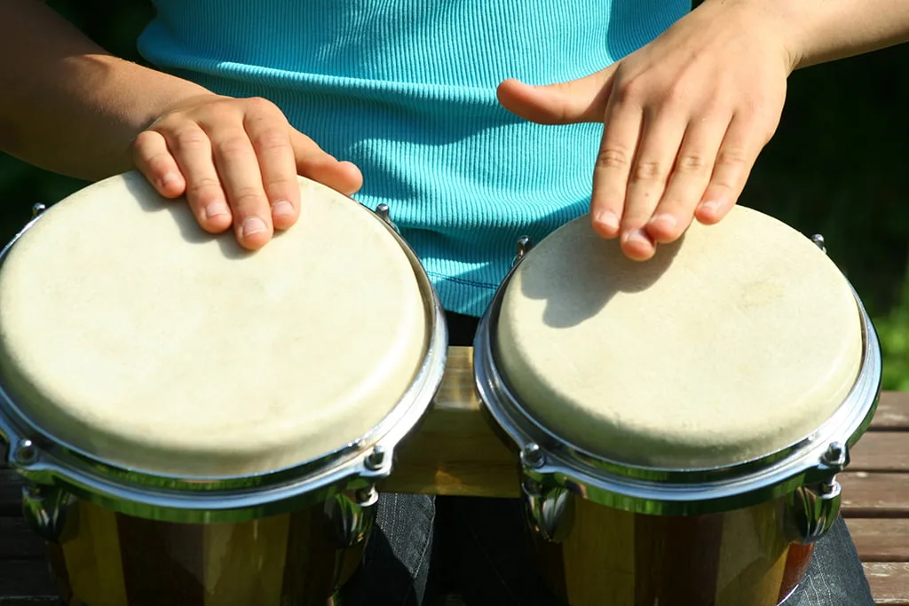 Un chico tocando unos Bongos