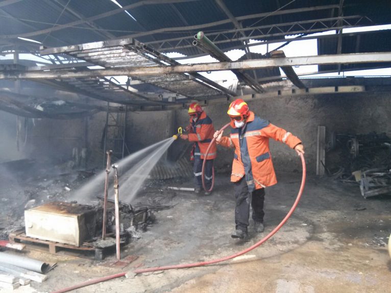 Bomberos sofocando las llamas en el almacen municipal de Xàbia