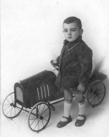 Niño junto a un coche de juguete