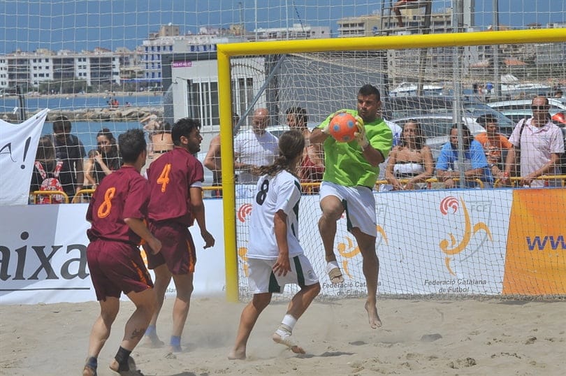 Portero blocando un balón en un choque de fútbol playa