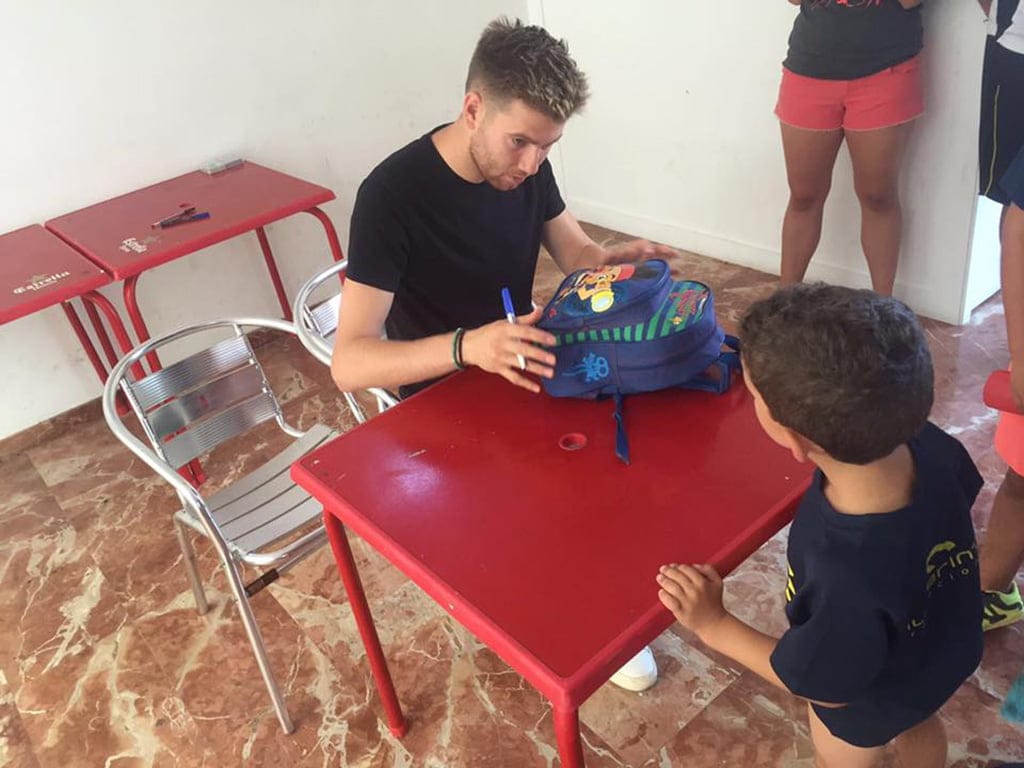 Adrián Ortolá firmando una mochila