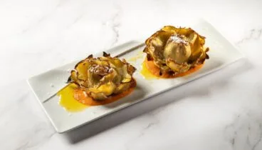 Alcachofas a la brasa con salsa romesco y lascas de parmesano