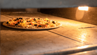 Pizza de masa fina y crujiente recién horneada en Jávea