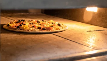 Pizza de masa fina y crujiente recién horneada en Jávea