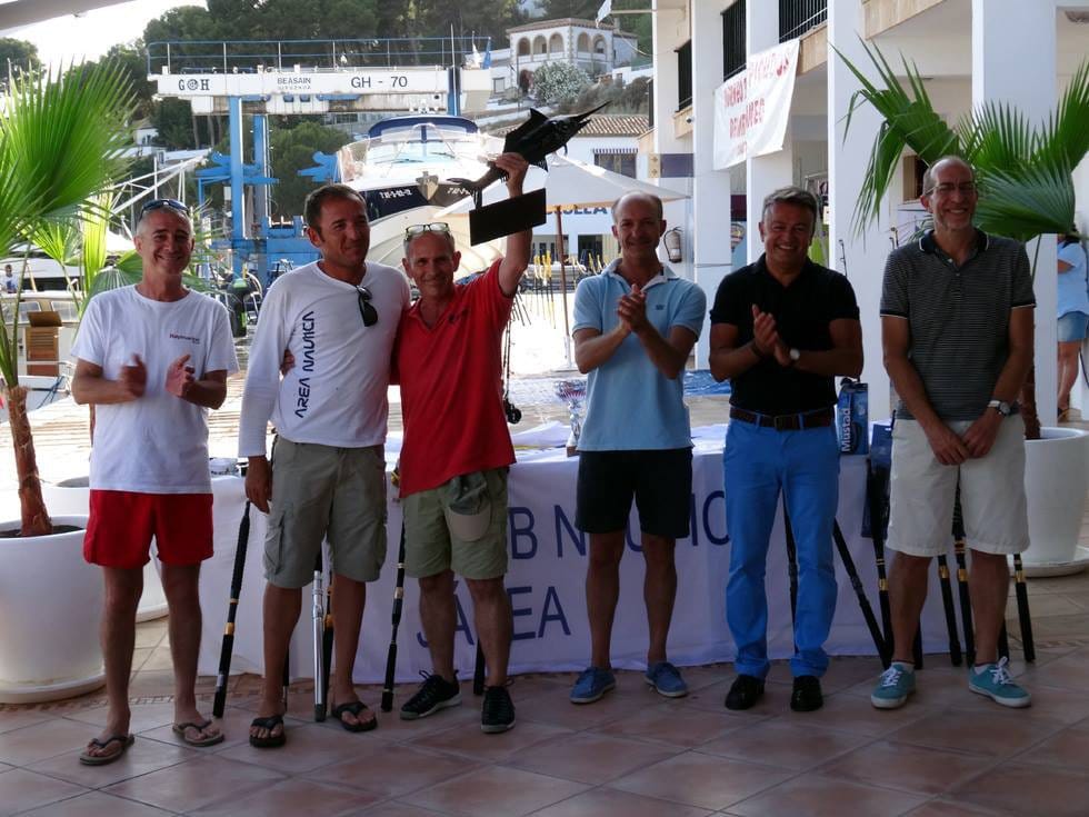 Uno de los ganadores luciendo el trofeo