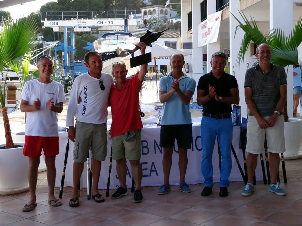 Uno de los ganadores luciendo el trofeo
