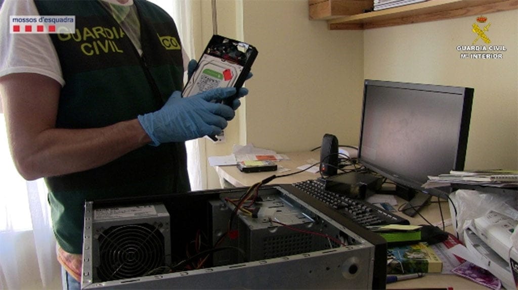 Guardia Civil con un disco duro en la mano