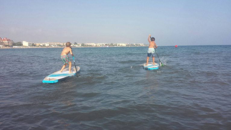 Dos niños sobre tablas de paddel Surf