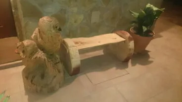 Figura de buhos y bancos hechos tallando troncos