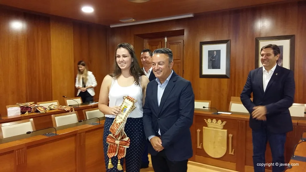 La segunda dama de honor junto al alcalde recogiendo la banda