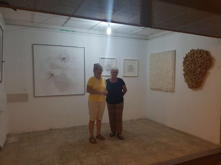 Mari Marí y María José Cholbi junto a la exposición