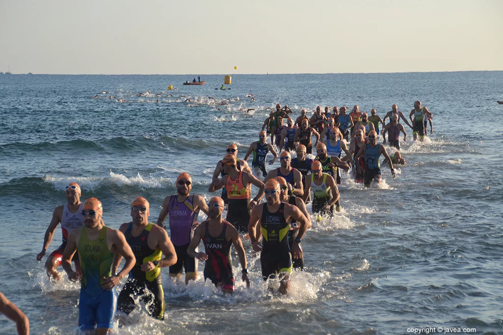 Rosario de triatletas saliendo del mar