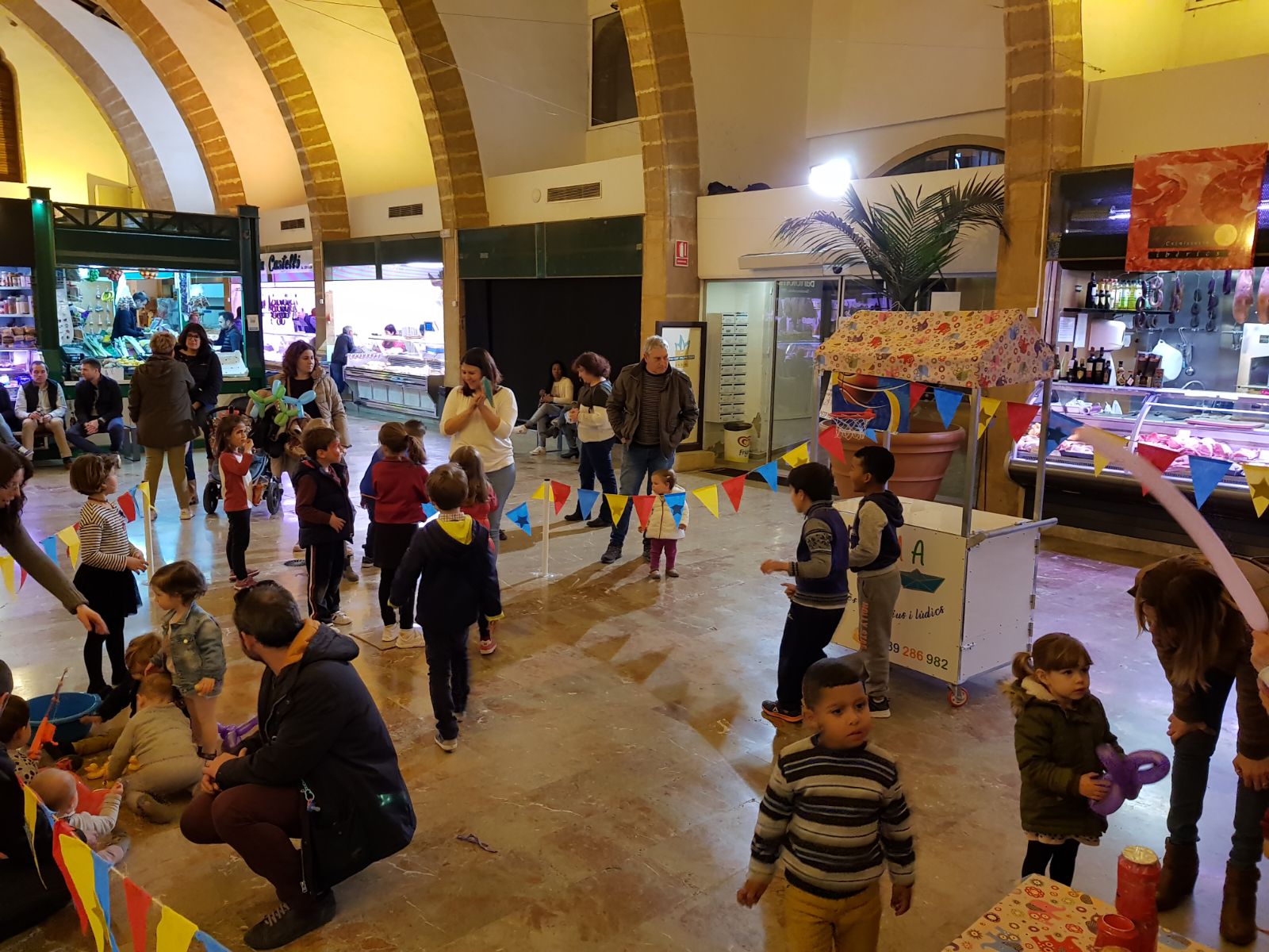Niños y mayores participan en los talleres infantiles del Mercat