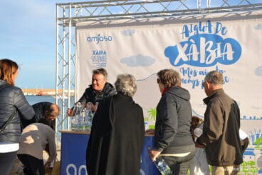 Decenas de personas acuden al reparto de botellas de cristal