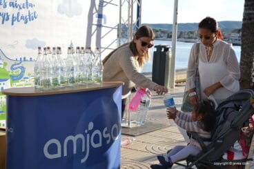 Decenas de personas acuden al reparto de botellas de cristal