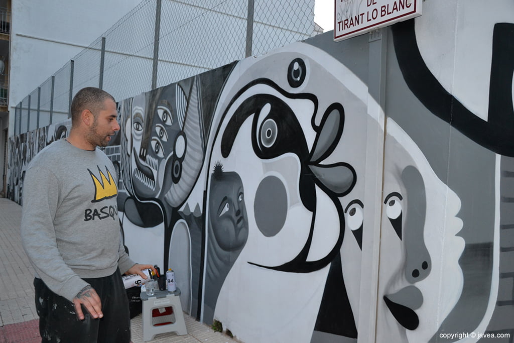 Gabriel López pintando el mural