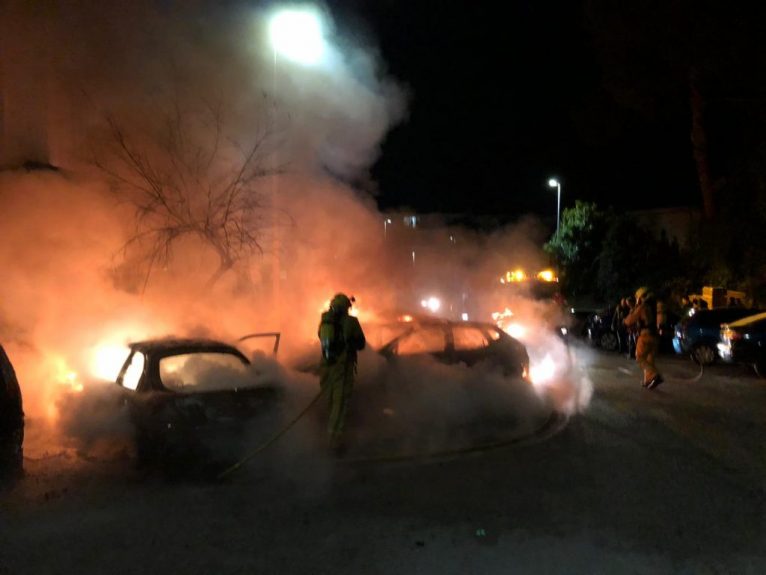 Bomberos apagando el fuego de los vehículos