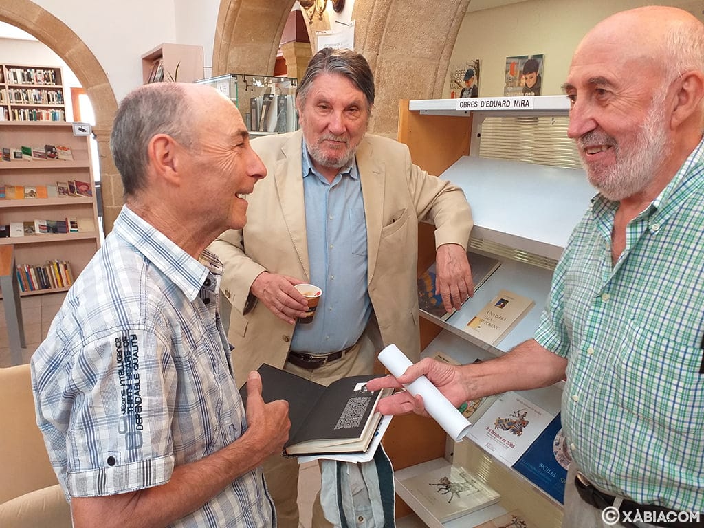Imagen: Eduard Mira junto a vecinos que han asistido a la donación de libros