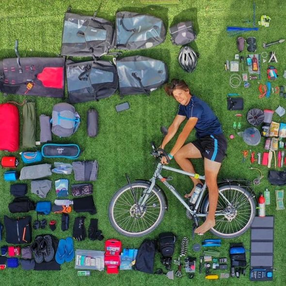Imagen: Lucas Muniz junto a todo el material que lleva en la bicicleta