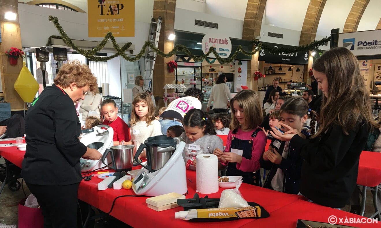 Los niños y niñas elaboran turrón en el taller de cocina del Mercat de Xàbia
