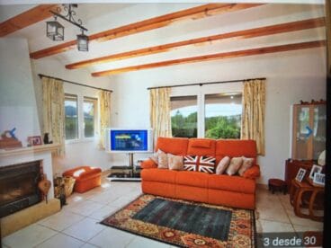 Salón con chimenea en un chalet en venta en Jávea – Atina Inmobiliaria