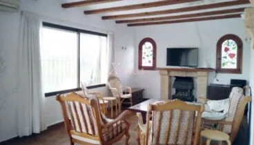 Zona de estar con chimenea en un chalet en venta en Jávea – Xabiga Inmobiliaria