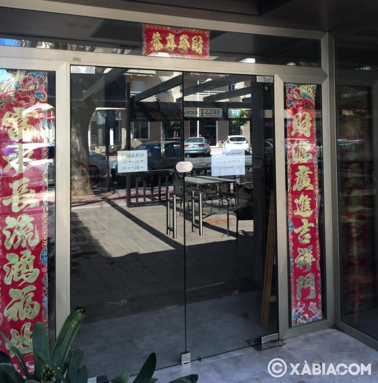 Restaurante asiático con cartel de cerrado por vacaciones