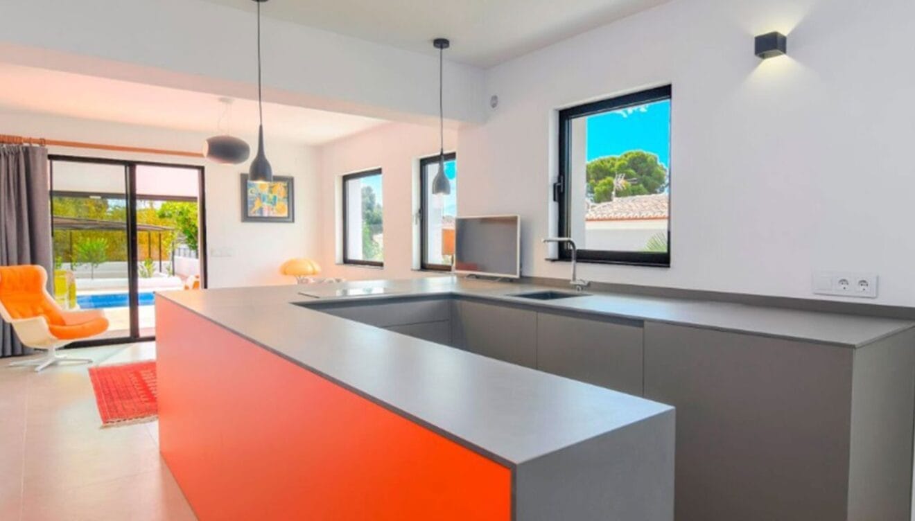Cocina con detalles naranjas en una villa en venta en el puerto de Jávea - MORAGUESPONS Mediterranean Houses