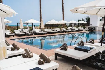 Piscina con tumbonas y parasoles en Purobeach Dénia