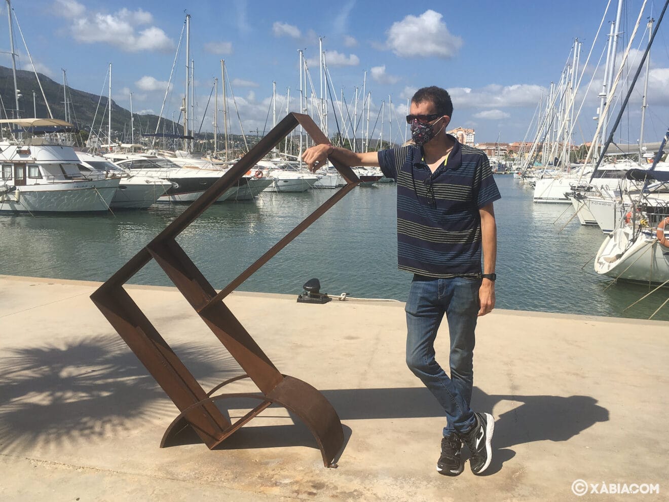 El artista Juan Carava junto a su obra