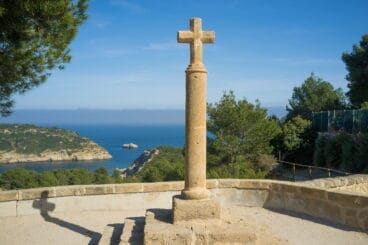 Imagen de la Cruz del Portitxol, con la Isla del Portitxol al fondo