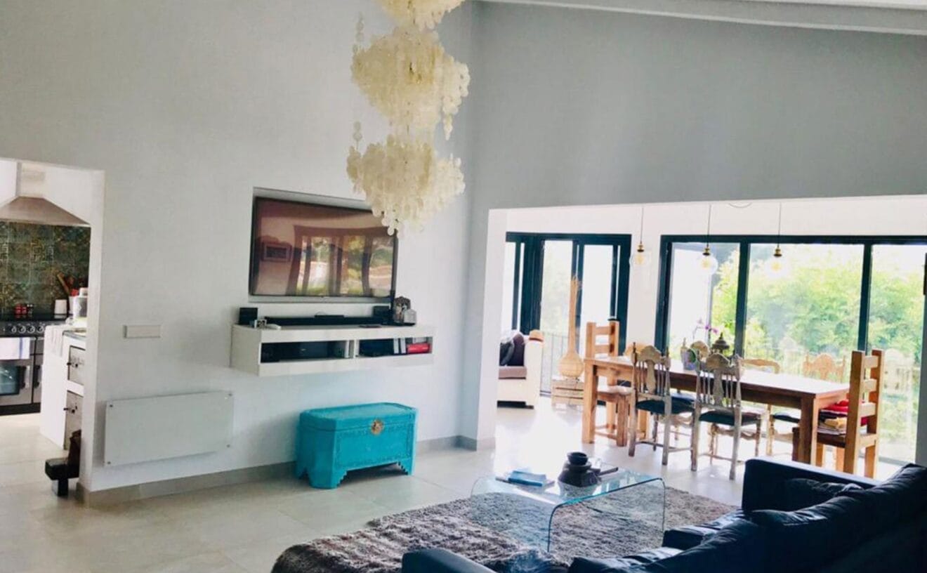 Salón de un chalet en venta de estilo ibicenco - Atina Inmobiliaria