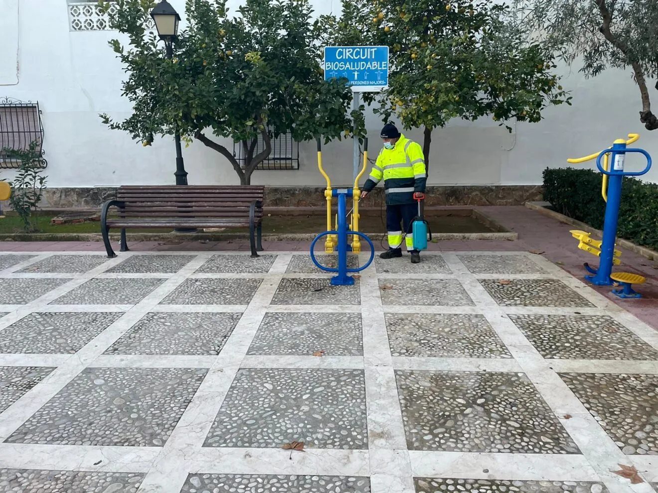 Operario realizando desinfección de mobiliario urbano