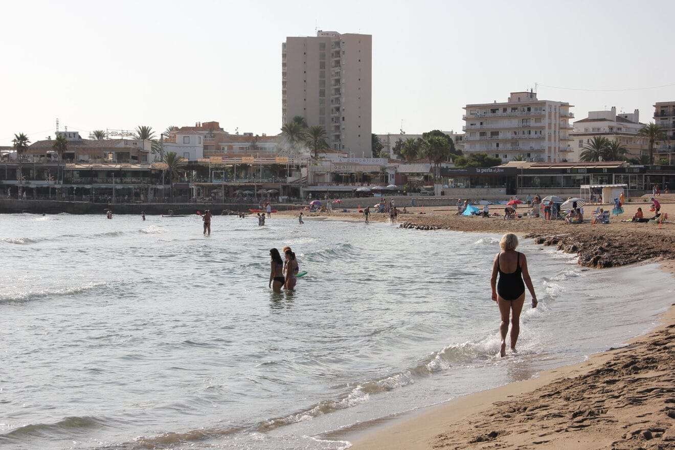 Los bañistas pasean por la orilla de la playa