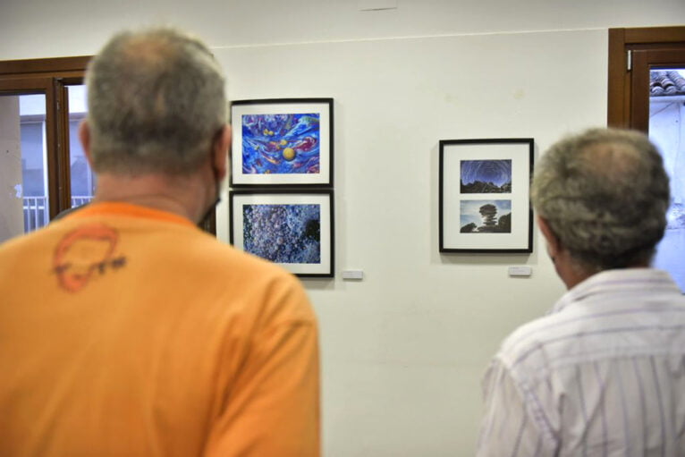 Público observando algunas fotografías de la exposición