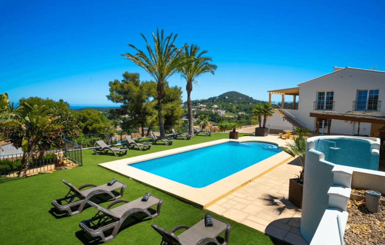 Amplia piscina con barbacoa y duchas exteriores en esta villa de Jávea