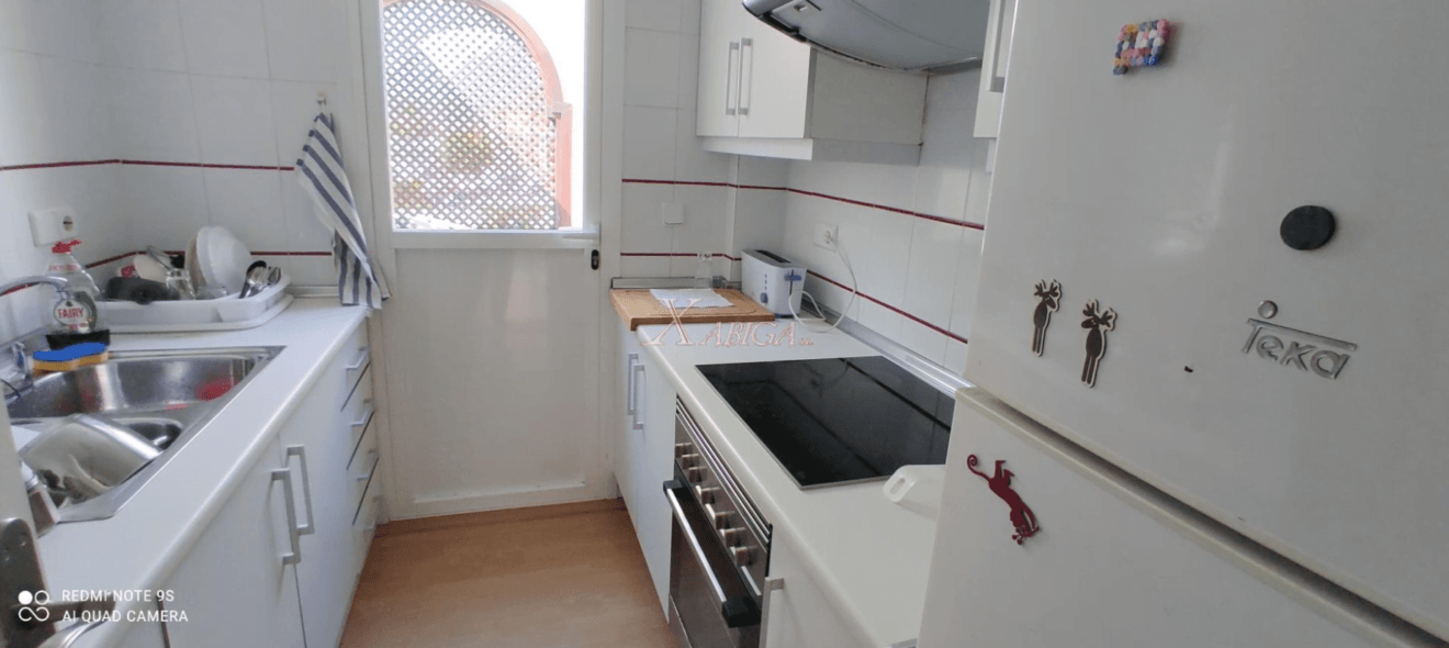 Cocina con acceso a la terraza del apartamento en venta con Xabiga Inmobiliaria