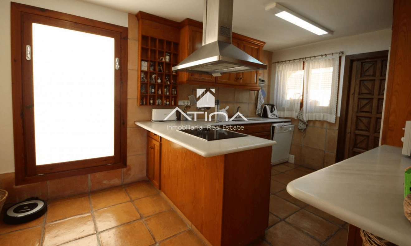 Cocina en madera con barra americana de esta villa de Atina Inmobiliaria